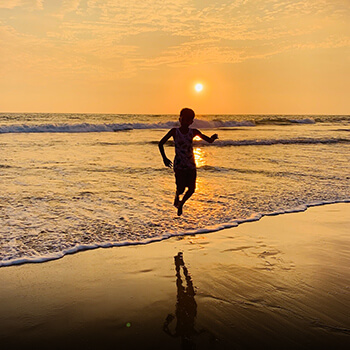 Child playing by the ocean in the evening