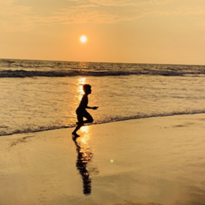 Child playing on the beach in the evening