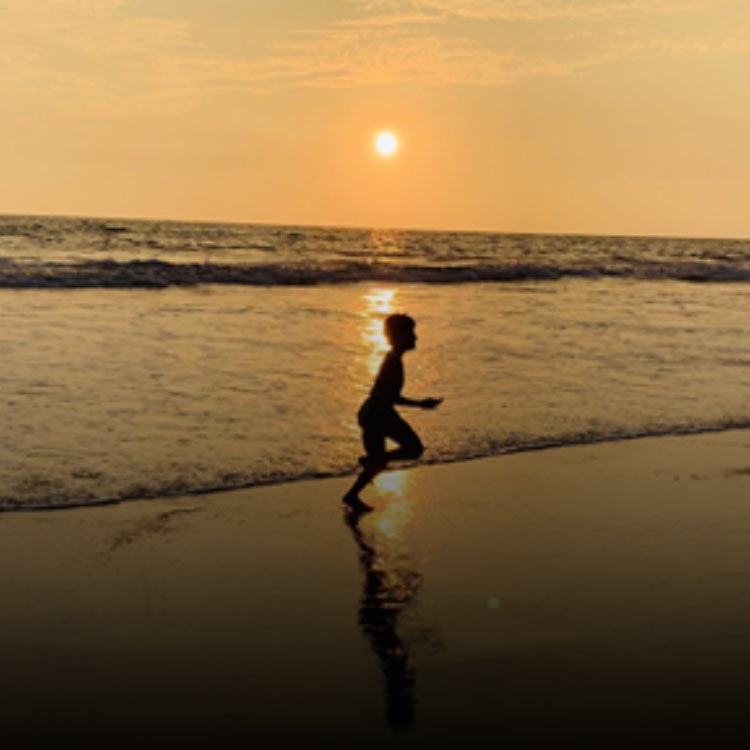 Child playing by the ocean in the evening