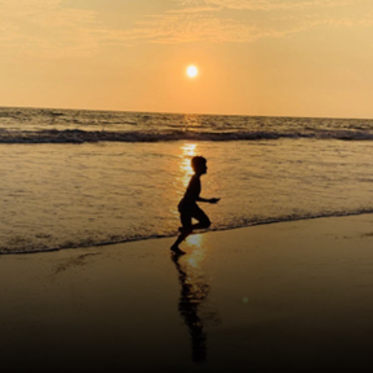 Child playing by the ocean in the evening